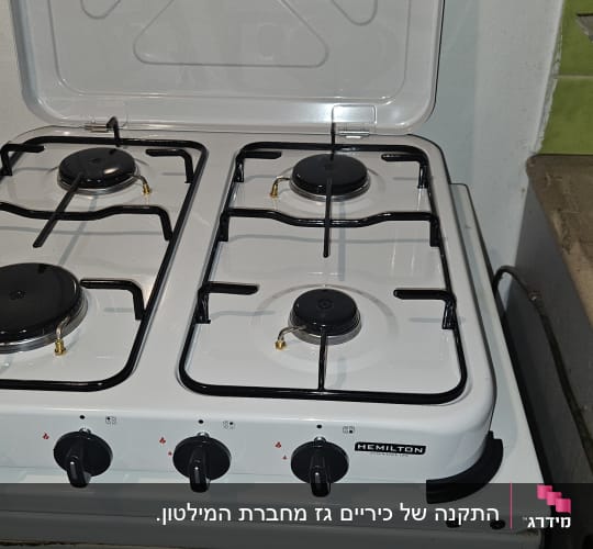 כיריים גז עם ארבעה מבערים וכפתורי שליטה